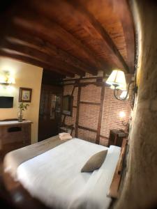 1 dormitorio con 1 cama blanca grande en una habitación en Hospederia Casa de Cisneros en Toledo