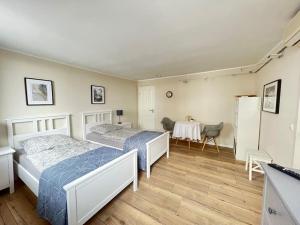 Dos camas en una habitación con mesa y sillas. en Tolle 2 Zimmer Wohnung Nähe ICE, en Siegburg