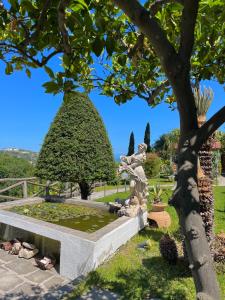 una fuente en un jardín con una estatua en Resort Villa Flavio, en Isquia