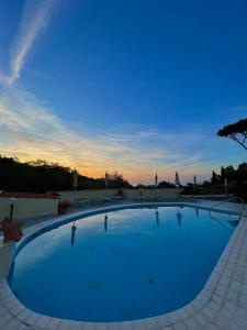 イスキアにあるResort Villa Flavioの夕日を背景に広いスイミングプール