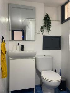 Un baño con un inodoro blanco y un lavabo. en Haro Plaza Centro, en Haro