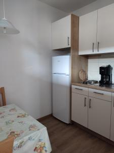 a kitchen with white cabinets and a white refrigerator at Appartement Windisch in Tirolo