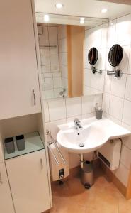 y baño con lavabo blanco y espejo. en Maria Alm - komfortables Apartment Gipfelglück en Saalfelden am Steinernen Meer