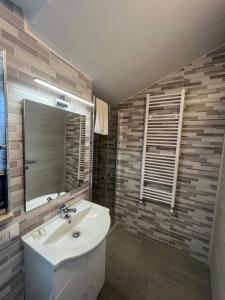 une salle de bain avec un lavabo et un miroir dans l'établissement beb Dragonara apartment 2, à Torre Maggiore