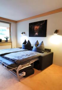 1 dormitorio con 1 cama grande con almohadas azules en Maria Alm - komfortables Apartment Gipfelglück en Saalfelden am Steinernen Meer