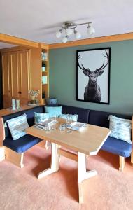 un comedor con una mesa y una foto de un ciervo en Maria Alm - komfortables Apartment Gipfelglück en Saalfelden am Steinernen Meer