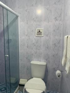W łazience znajduje się toaleta i przeszklony prysznic. w obiekcie Pousada Du’Forte w mieście Praia do Forte