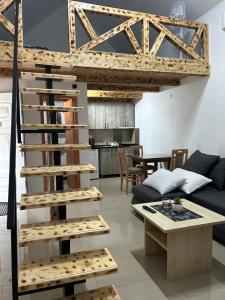 a spiral staircase in a living room with a couch at Zeleni Raj Apartmani in Vrdnik