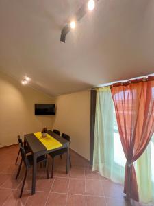 une salle à manger avec une table et des chaises et une fenêtre dans l'établissement beb Dragonara apartment 2, à Torre Maggiore 15 autres photos