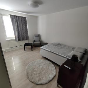 um quarto com uma cama, uma cadeira e um tapete em SEA - 3 Bedrooms em Kristiinankaupunki