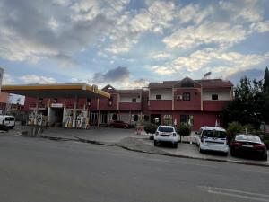 una gasolinera con coches aparcados delante en Hotel Tanout en Azilal