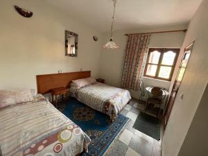 una camera con due letti e una finestra di Hotel Tanout ad Azilal