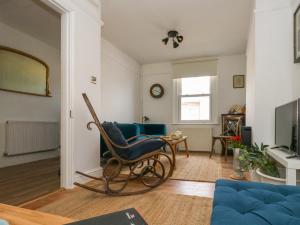 un salon avec un fauteuil à bascule et une télévision dans l'établissement 26 High West, à Weymouth