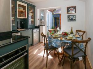 une cuisine avec une table et des chaises et une cuisine avec une table dans l'établissement 26 High West, à Weymouth