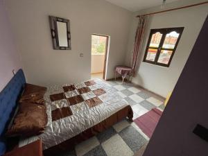 1 dormitorio con cama y espejo en la pared en Hotel Tanout en Azilal