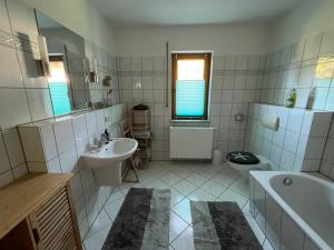 a white bathroom with a sink and a toilet at Ferienwohnung Am Kiessee Birkwitz in Pirna