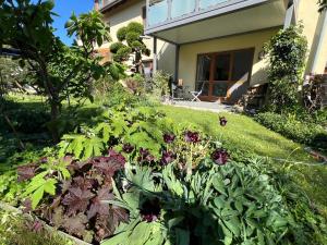a garden in front of a house with flowers at Ferienwohnung Am Kiessee Birkwitz in Pirna