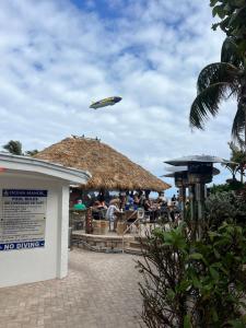un aereo che vola sopra un ristorante con tetto di paglia di Ocean Manor Tiki Sunset Retreat a Fort Lauderdale