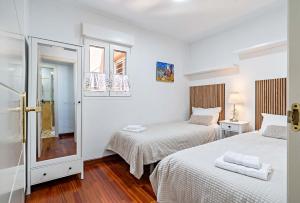 two beds in a room with white walls and wood floors at Vista del Mar Residencial in Roquetas de Mar +37 photos