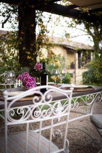 a table with a bottle of wine and wine glasses at Ca' le cerque, villa surrounded by the Marche nature in Fossombrone