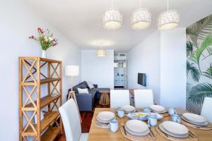 a dining room with a table with white plates and chairs at Vista del Mar Residencial in Roquetas de Mar