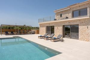a house with a swimming pool next to a building at Brand New Kefalonia Stone Villas - Villa Trapezaki Tranquility in Trapezaki