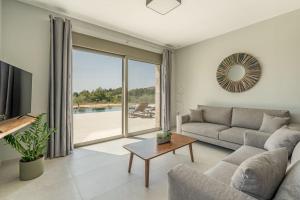 a living room with a couch and a table at Brand New Kefalonia Stone Villas - Villa Trapezaki Tranquility in Trapezaki