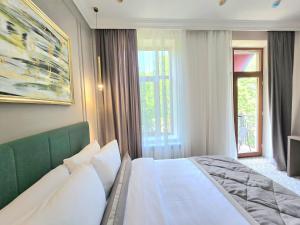 ein Schlafzimmer mit einem weißen Bett und einem Fenster in der Unterkunft Maestro Address Hotel in Baku