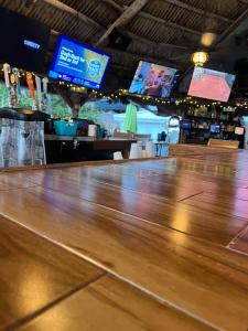 um close-up de um bar de madeira com televisões em Ocean Manor Tiki Sunset Retreat em Fort Lauderdale