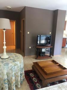 Una sala de estar con una mesa y un televisor. en Elit Sunny Beach, en Sunny Beach