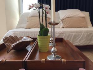 Una mesa de café con una vela y flores sobre una cama. en Elit Sunny Beach, en Sunny Beach 2 fotos más