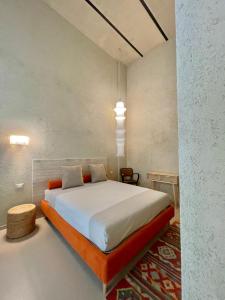 a bedroom with a large white bed with an orange bed frame at FUTURA ROOM&RELAX in Termoli