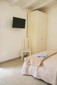 a bedroom with a bed and a chair and a tv at Villa il Poderino in Marina di Campo
