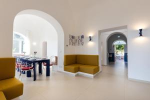 a living room with yellow chairs and a table at AMORE RENTALS - Villa Olivella in Anacapri