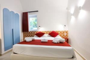 a bedroom with a large bed with red pillows at AMORE RENTALS - Villa Olivella in Anacapri +68 photos