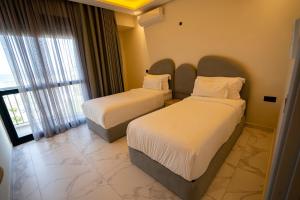 pokój hotelowy z 2 łóżkami i oknem w obiekcie Le Rio Appart-Hotel City Center w mieście Tanger