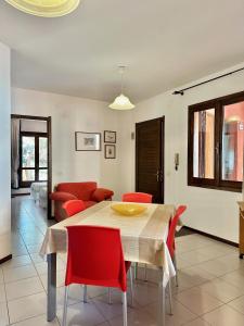 a dining room with a table and red chairs at Moresca Apartment by Jennas in Àrbatax