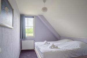 a bedroom with a bed with two stuffed animals on it at Comfort Villa for 8 People in Zeewolde +15 photos