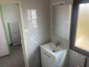 W białej łazience znajduje się umywalka i lustro. w obiekcie Casa Tía Blanca w mieście Valverde