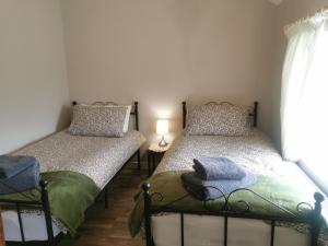 two twin beds in a room with a window at Christie's Cottage in Dungiven