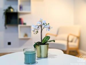 a flower in a pot and a glass on a table at L'Impressionniste - Spacieux - Lumineux - Central in Orléans