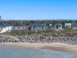 um bando de pássaros sentados na praia em Villa bord de mer pour 10 personnes em Portbail