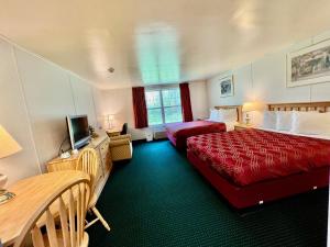 Cette chambre comprend deux lits et une télévision. dans l'établissement Rodeway Inn & Suites Brunswick near Hwy 1, à Brunswick