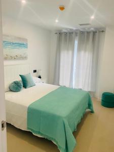 a bedroom with a large bed with blue pillows at Apartahotel Puerto Blue in Puerto de Mazarrón