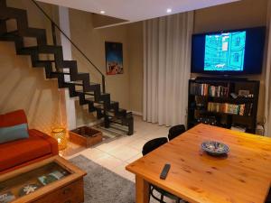 a living room with a couch and a table and a tv at Bright Loft in Cannes