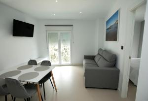 a living room with a table and a couch at Apartahotel Puerto Blue in Puerto de Mazarrón