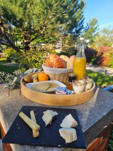 uma bandeja de queijo e pão e uma garrafa de sumo em Les Rauches - Quai Loire - Chambre Jungle em Châteauneuf-sur-Loire