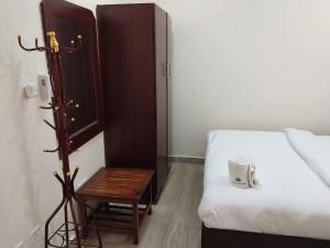 een slaapkamer met een bed en een kruk naast een tafel bij Tulba Hotel and Residences in Djoeba