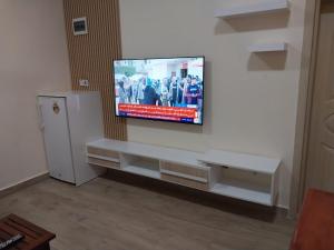 TV de pantalla plana colgada en una pared blanca en Tulba Hotel and Residences, en Yuba