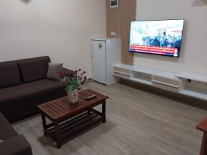 een woonkamer met een bank en een tv bij Tulba Hotel and Residences in Djoeba